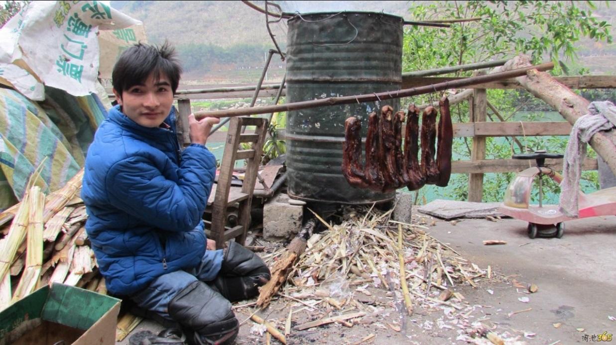 摊位后旧油桶是坚强哥制作腊肉的地方,在他的淘宝店,土猪腊肉也是畅销